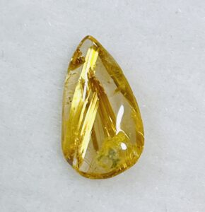 ゴールドの針状インクルージョンが美しい、ドロップ型ルチルクォーツのルース。