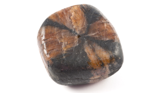 キアストライト（キャストライト）の原石。黒地に茶褐色の十字模様が浮かぶタンブル。