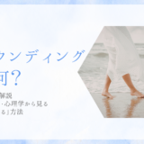 グラウンディングって何？意味や方法を解説。スピリチュアル・心理学から見る「地に足をつける」方法。白いワンピースの女性が波打ち際を裸足で歩くアイキャッチ画像